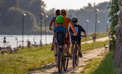 Family riding bikes along a river